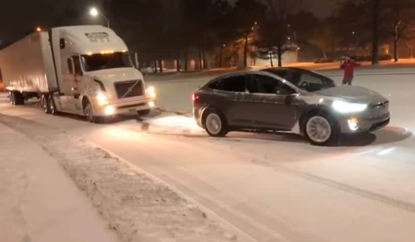 Tesla trekt vrachtwagen een besneeuwde heuvel op