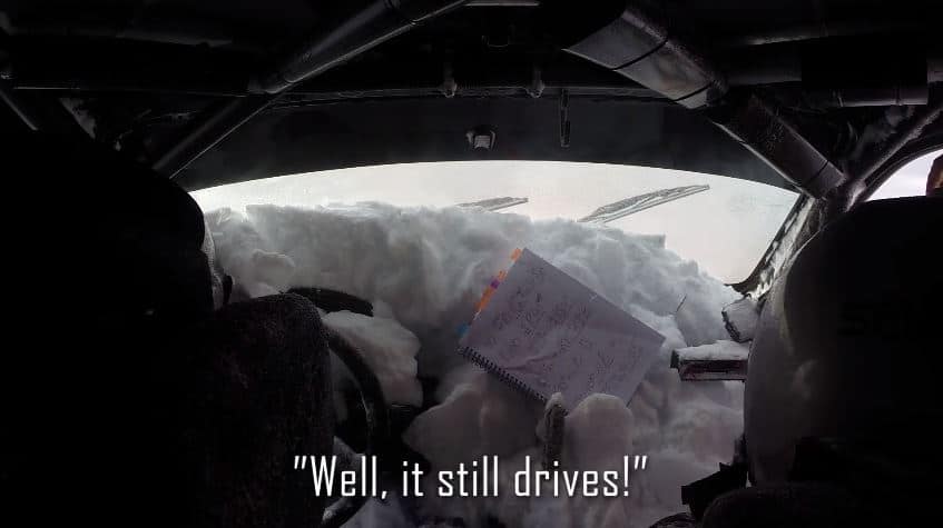 Rallycoureur rijdt met auto vol met sneeuw