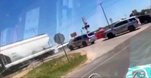 Politieagent wacht niet tot het rode licht gedoofd is bij spoorwegovergang
