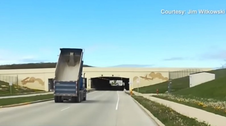 Chauffeur rijdt met laadbak omhoog richting tunnel